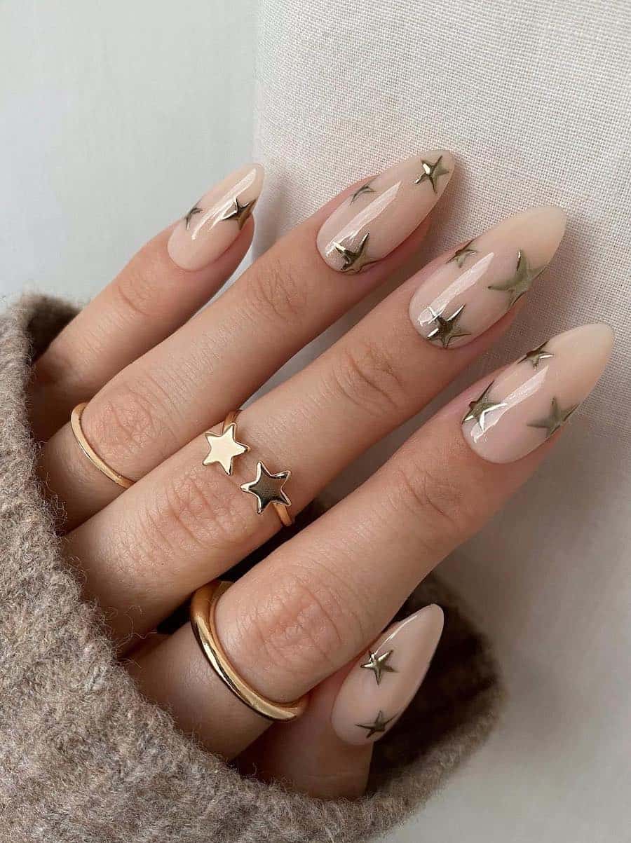 long milky beige almond nails with gold stars