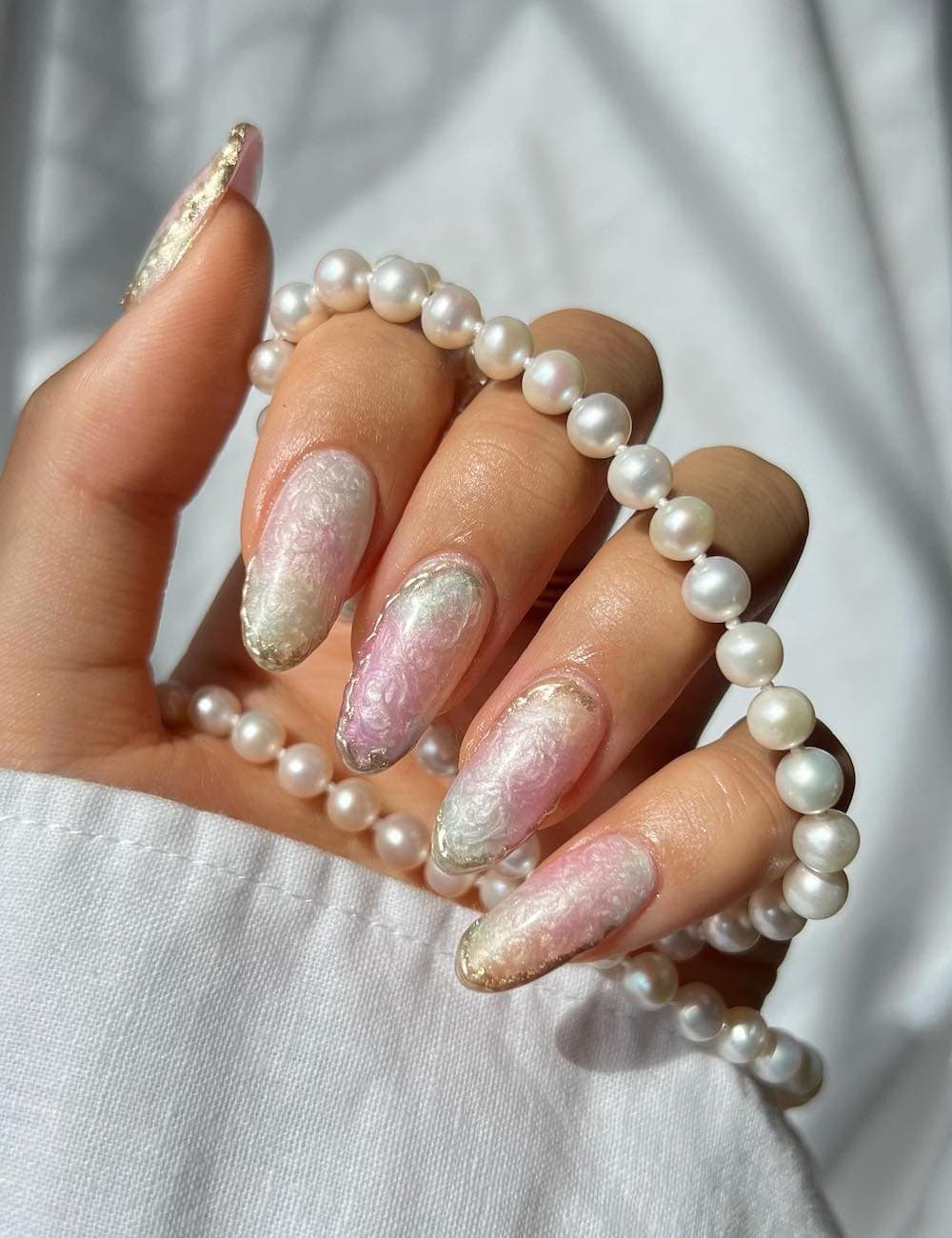 long almond nails with iridescent shades and a pearly finish
