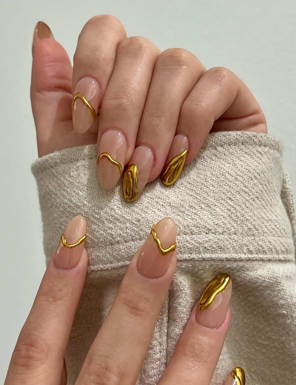 long nude almond nails with dripped gold french tips