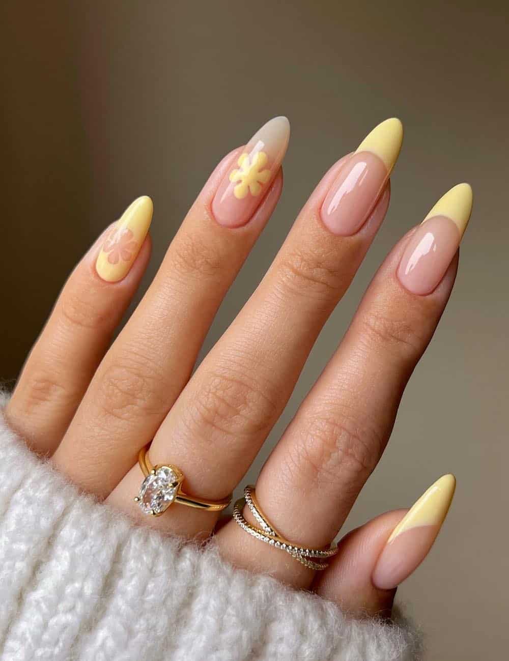 long nude almond nails with butter yellow french tips and floral accent nails