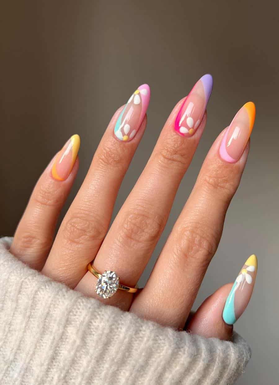 Long nude almond nails with colorful French tips and reverse French tips with floral nail art