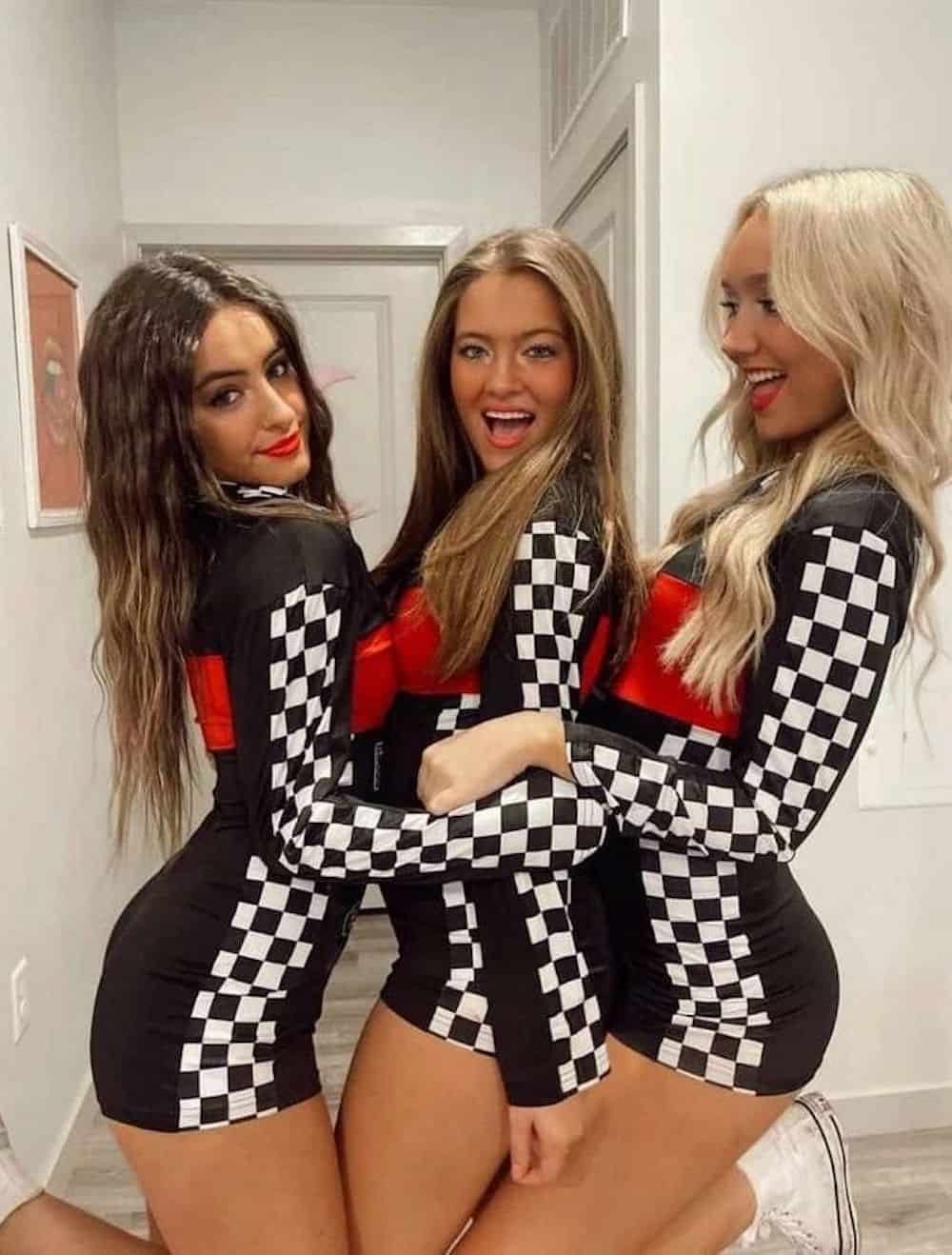 Three women dressed up as race car pit crew on Halloween.