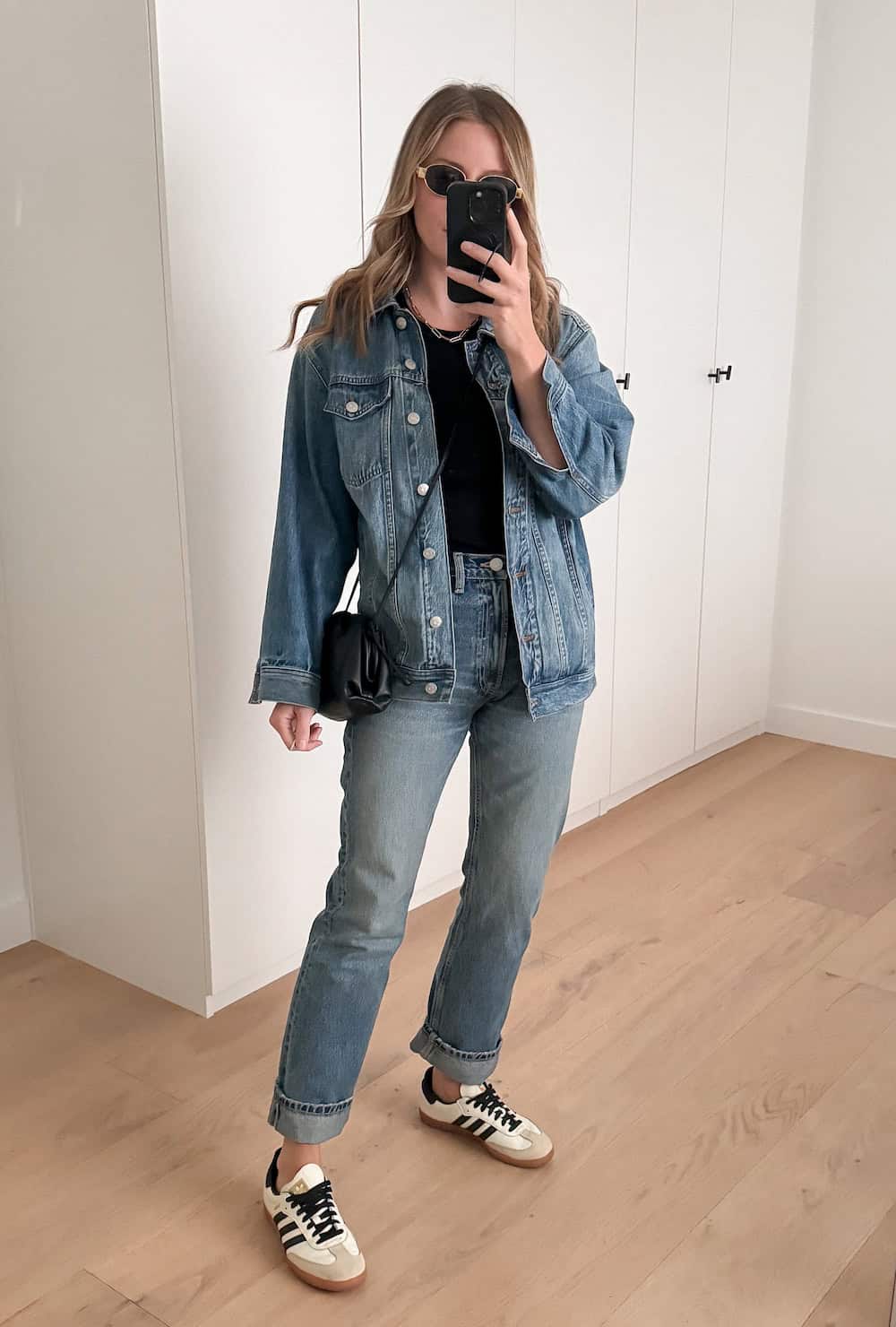 Christal wearing jeans with a matching denim jacket and a black t-shirt with sneakers.