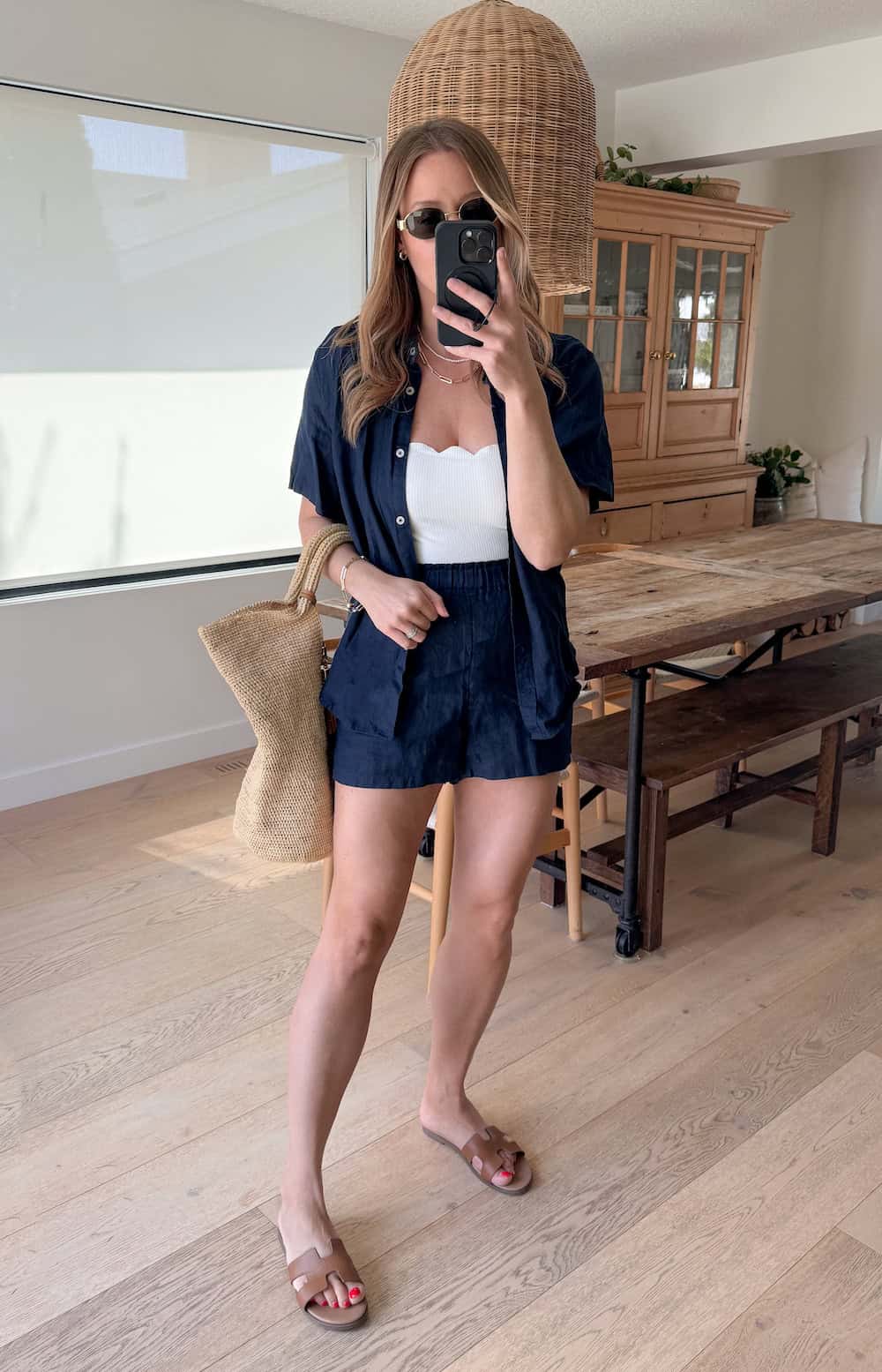 Christal wearing navy shorts with a white bodysuit and a navy button down.