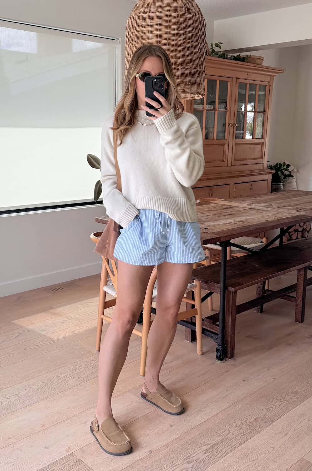 Christal wearing white and blue striped boxer shorts with a cream sweater and cozy shoes.