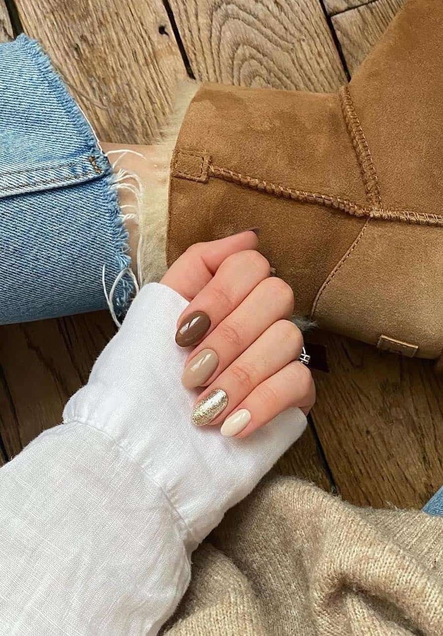 medium round nails with gradient brown, beige and cream polish and a shimmering gold accent nail
