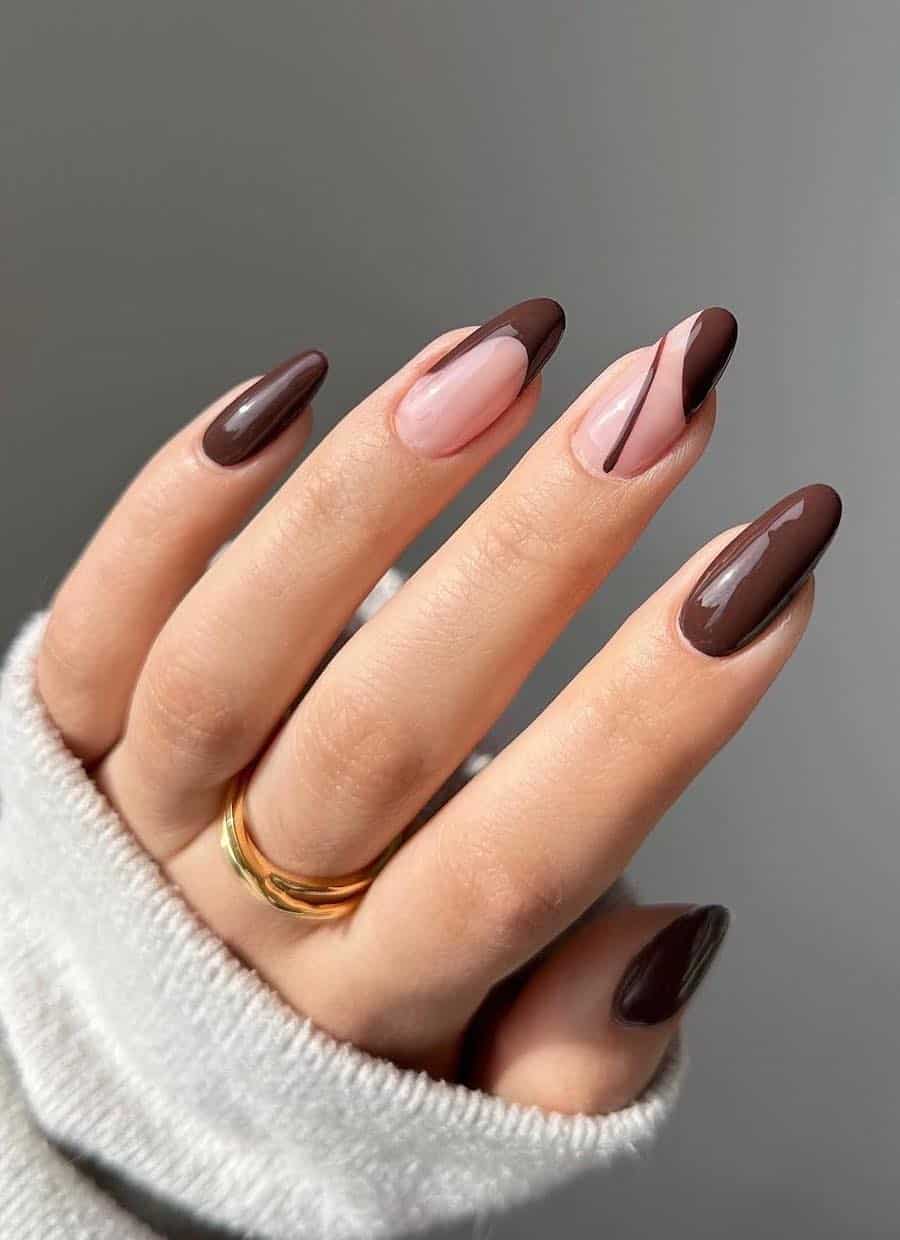 long brown almond nails with nude accent nails featuring asymmetrical brown tips and line accents