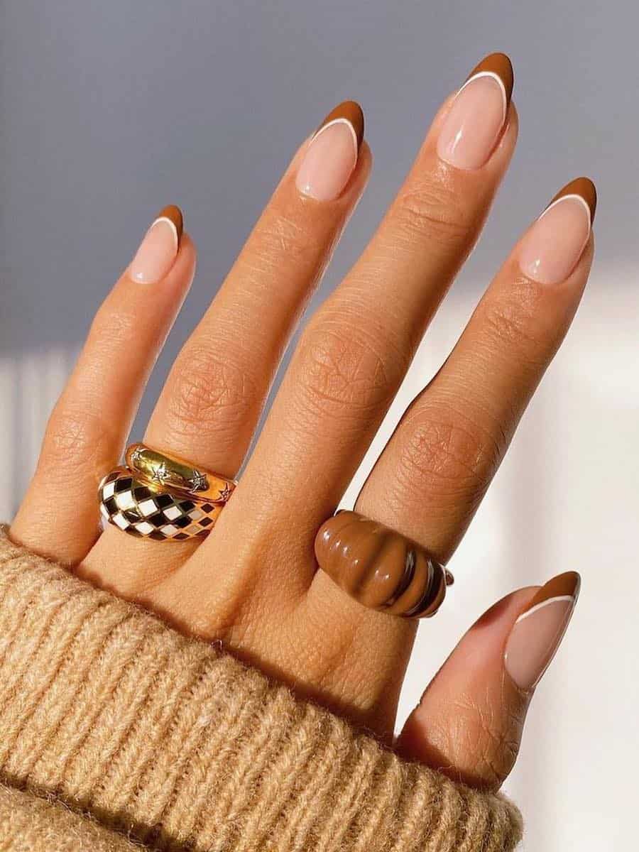 medium nude almond nails with light brown tips and white outlines