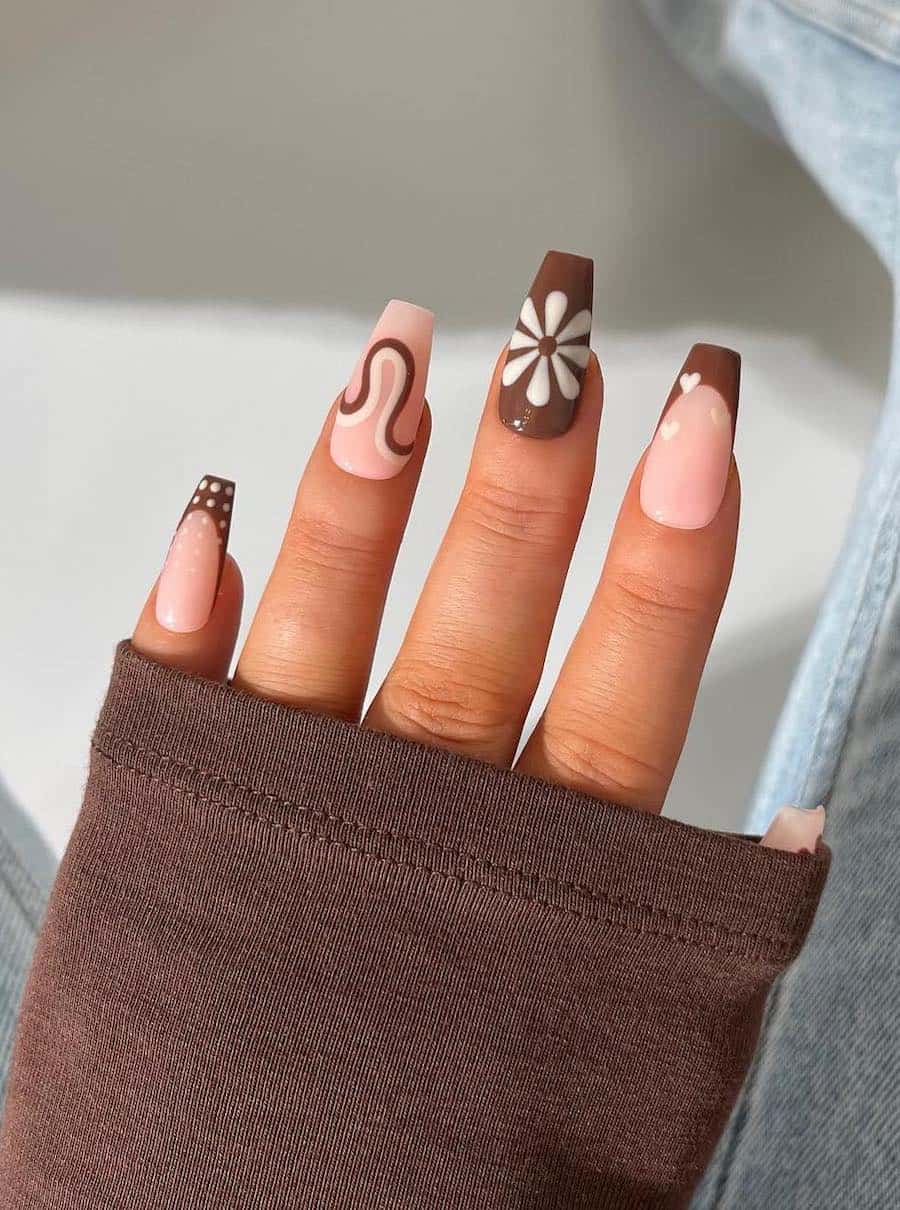long coffin nails with nude pink, brown, and white polish featuring a collage nail design