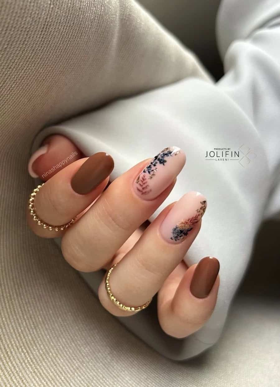 long nude pink round nails featuring fall floral nail art and two brown accent nails