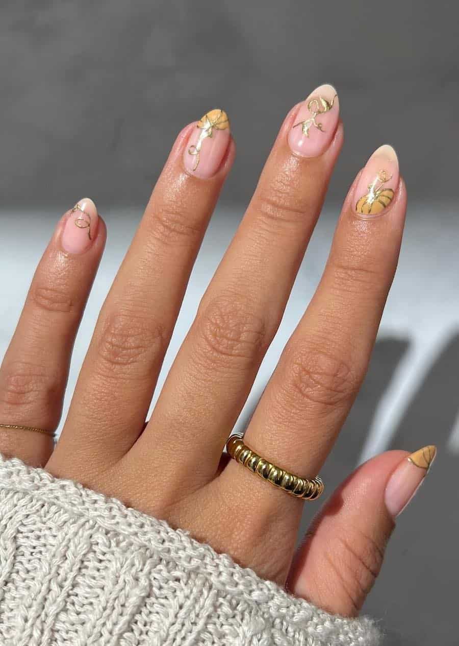 short nude almond nails with pastel orange pumpkin and gold nail art