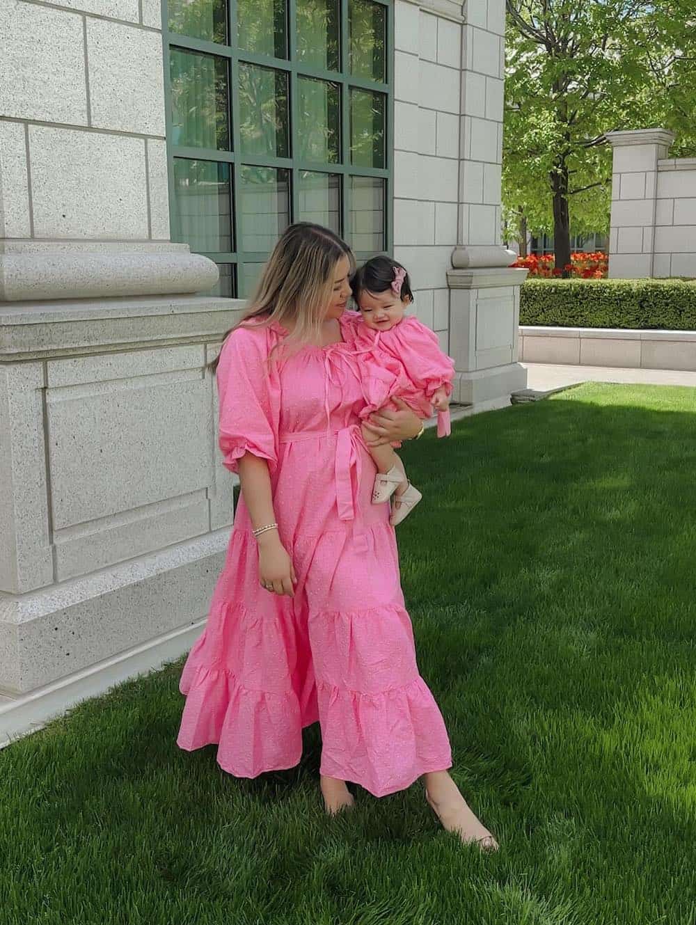 a summer family photo shoot with a mom and baby girl wearing matching bubblegum pink maxi dresses