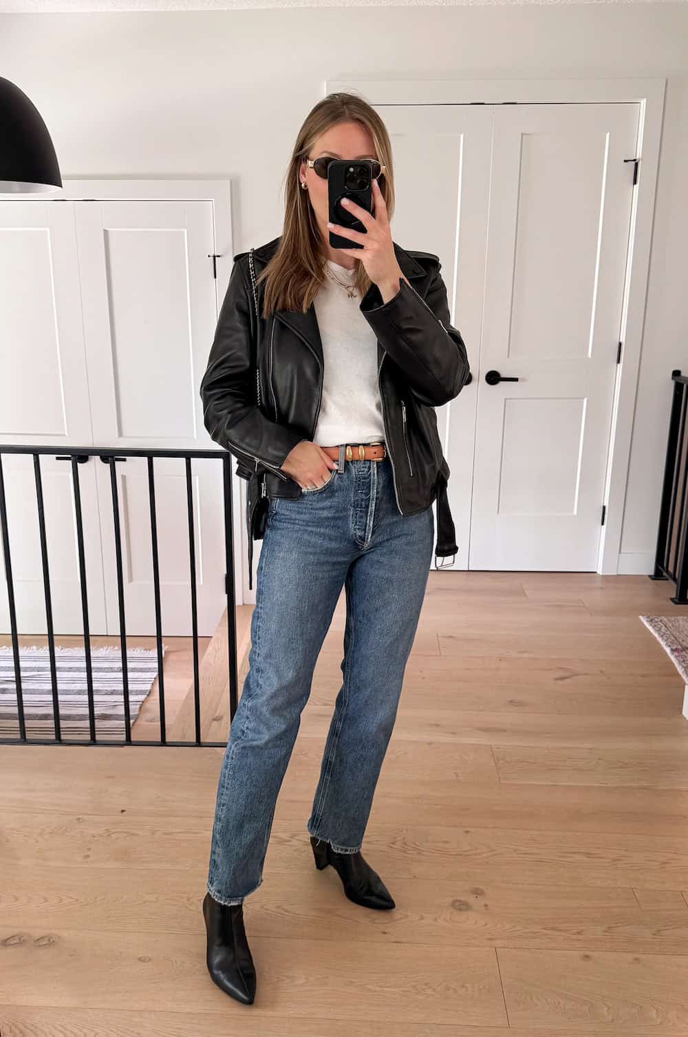 Christal wearing jeans, a white t-shirt, a black leather jacket and black booties.
