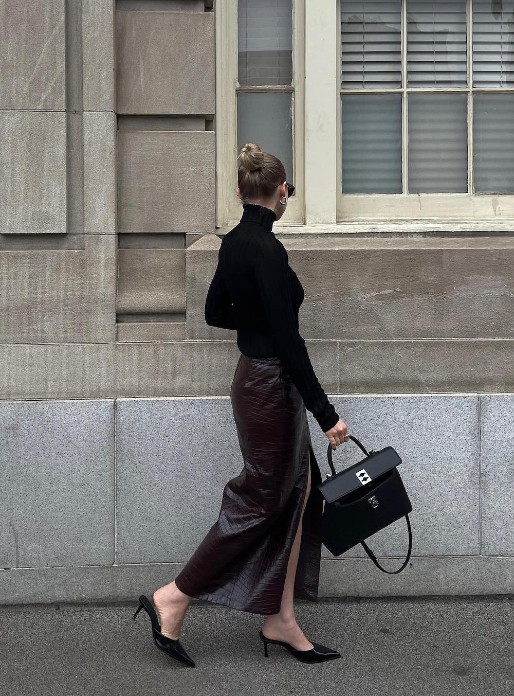 woman wearing a fall outfit with a black turtleneck and leather midi skirt with heels