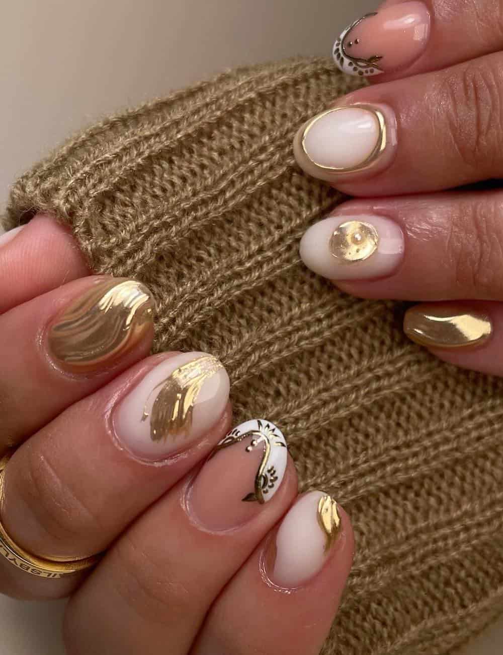 short round nails with milky white and nude nails featuring white and gold designs