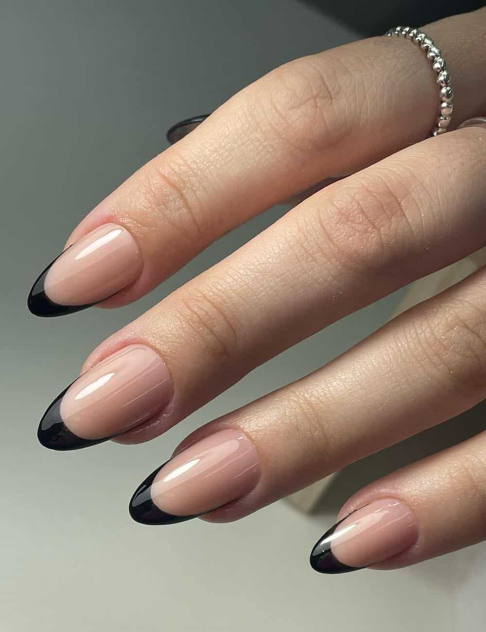 medium nude almond nails with black french tips