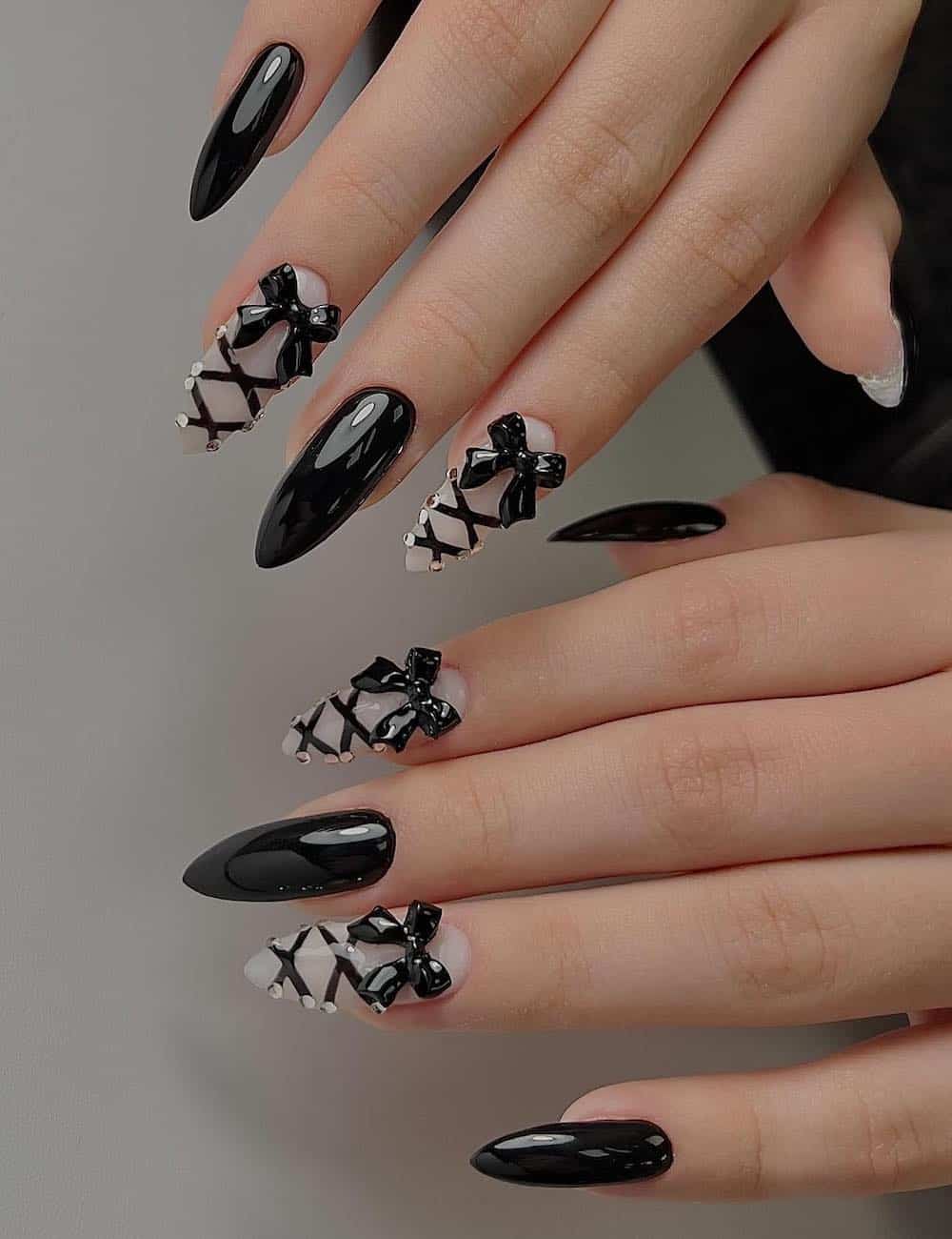 long stiletto nails painted black and milky white with lace-up nail art and black bow charms