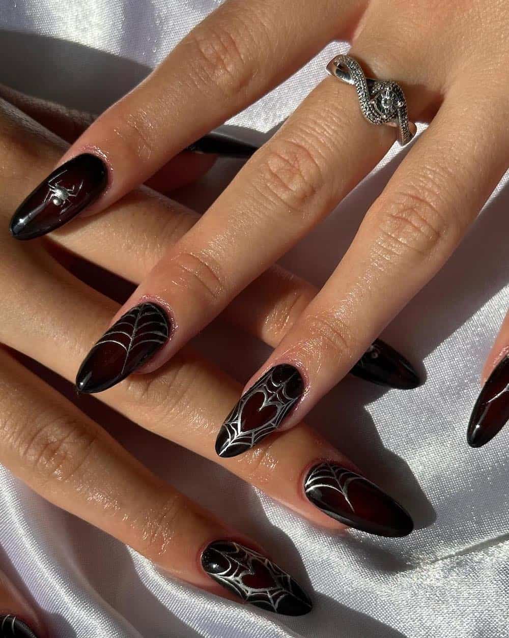 long red and black aura almond nails with silver Halloween nail art
