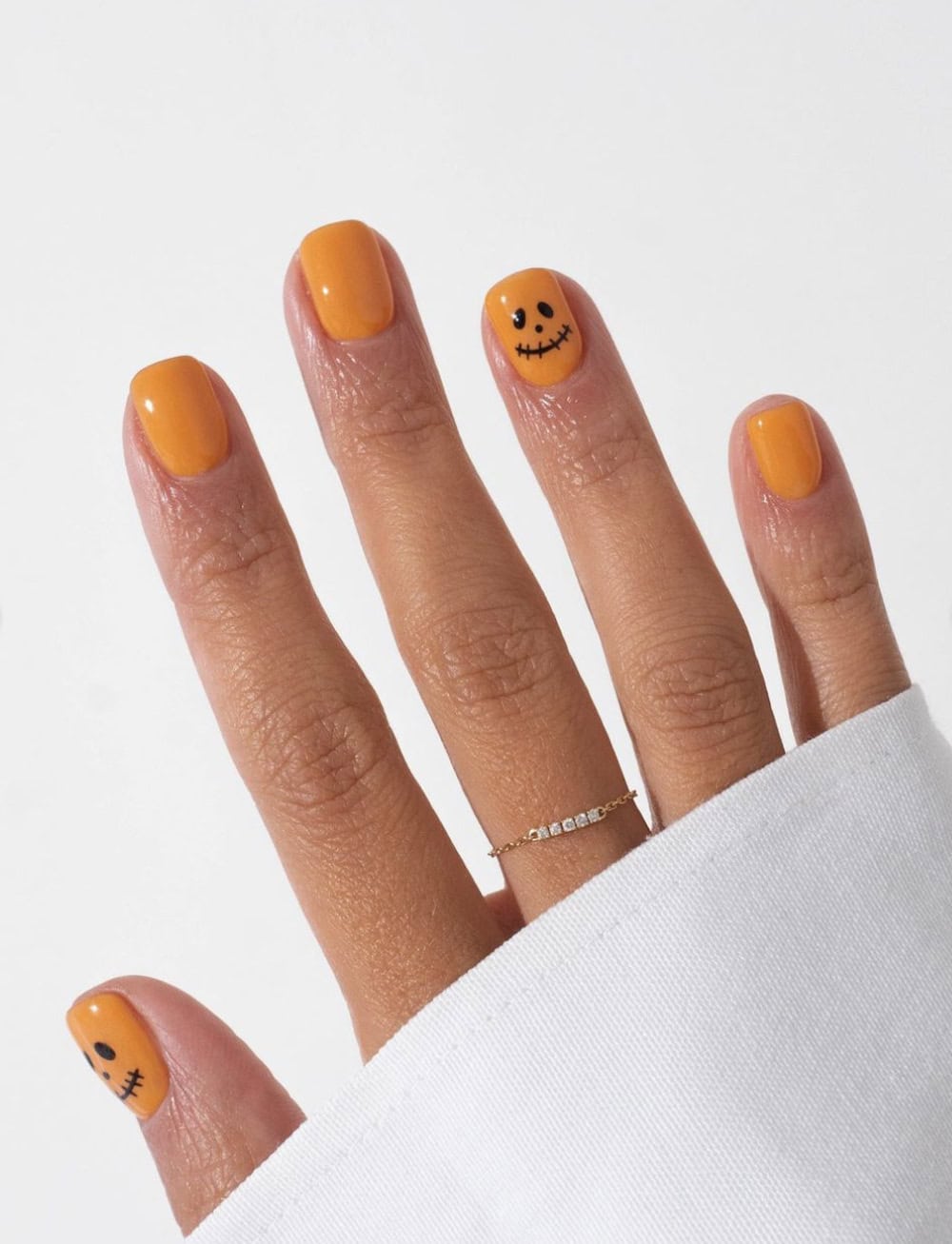 short orange nails with pumpkin face accent nails
