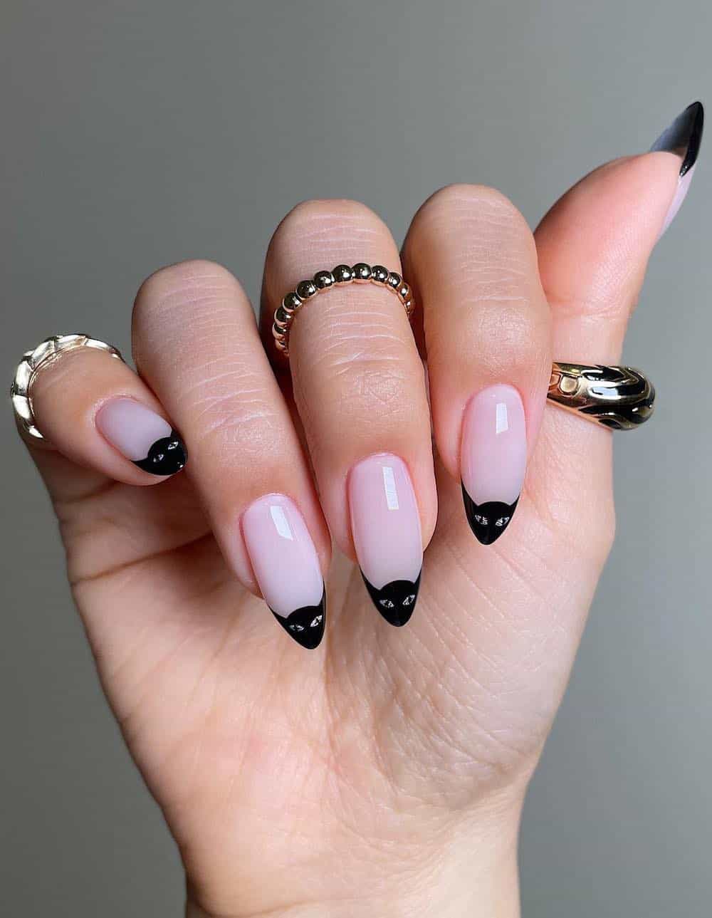 long nude pink almond nails with black cat tips