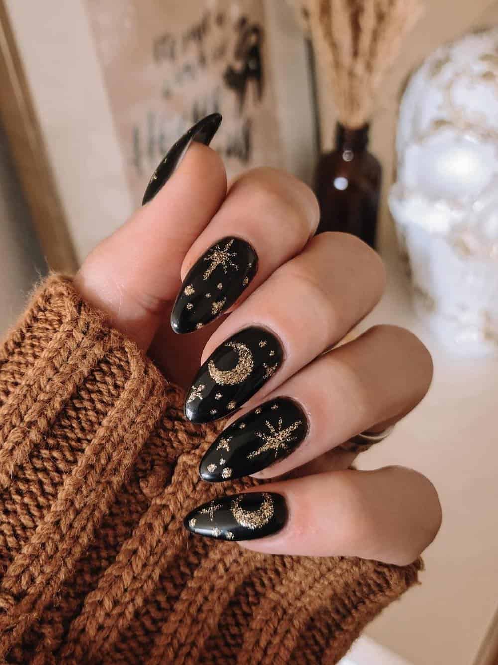 long black almond nails with gold glitter stars and moons
