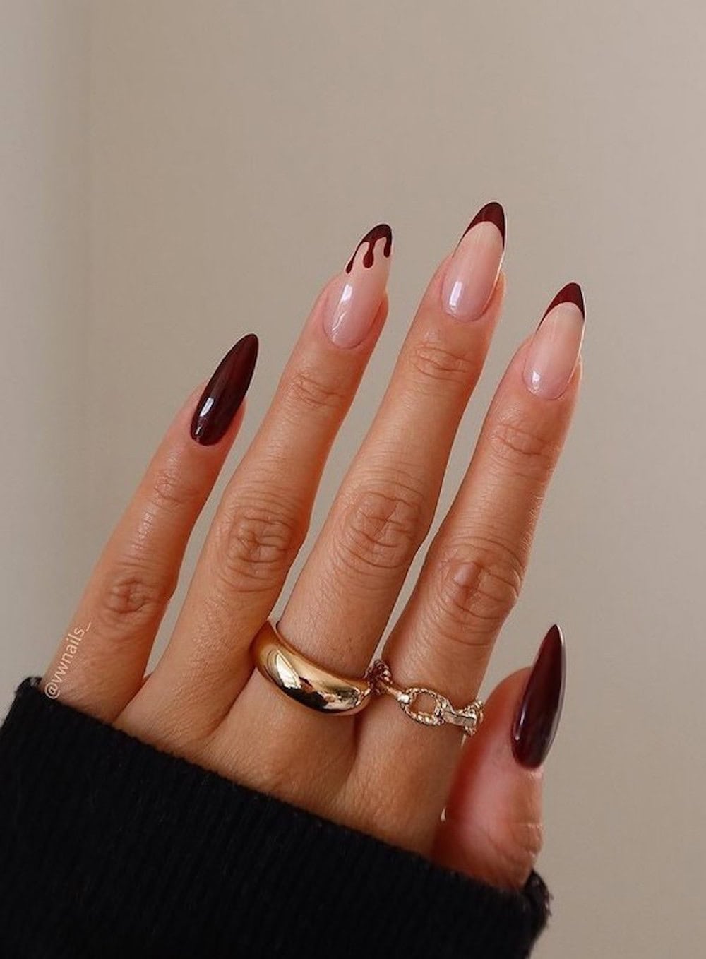 long nude almond nails with dark red tips, solid accent nails, and a dripping tip accent nail