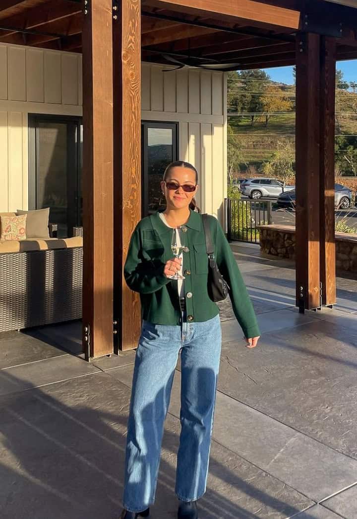 woman wearing a green jacket with jeans at a winery in the fall