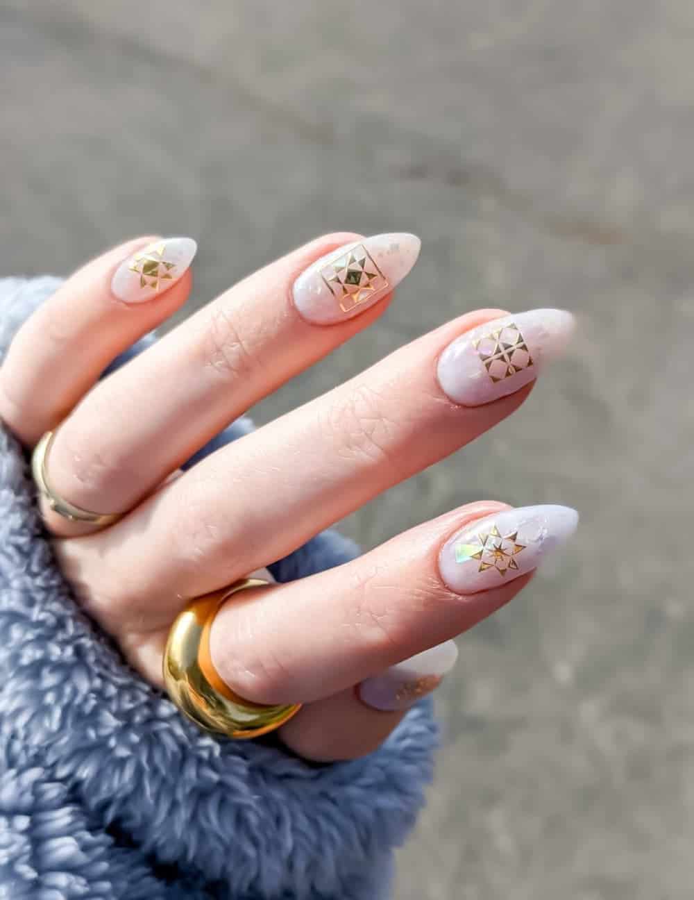 holographic white almond nails with gold accents