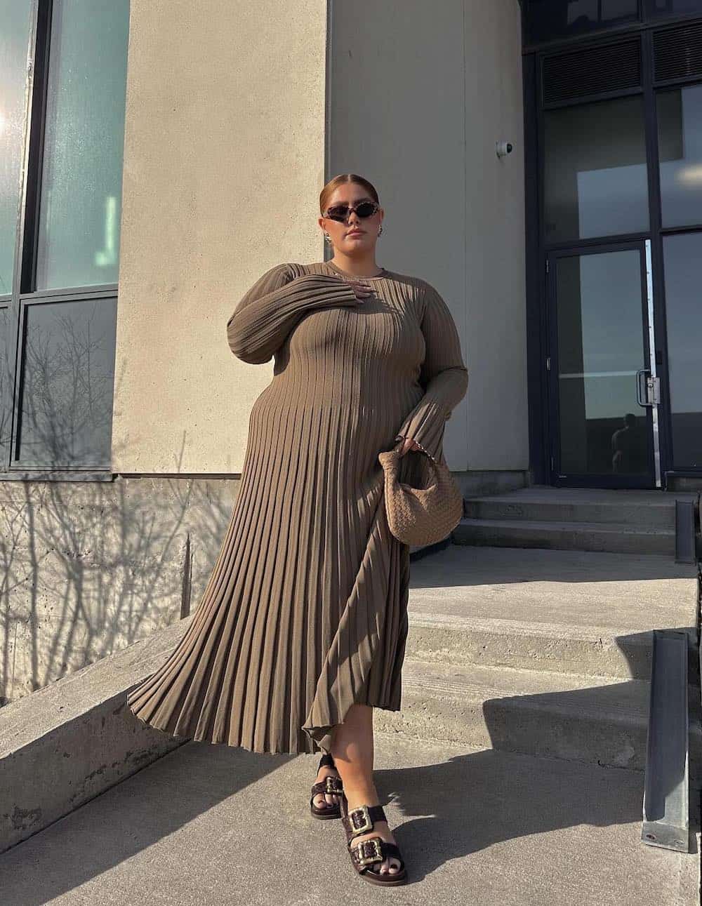 a woman wearing a beige midi sweater dress and brown buckled sandals