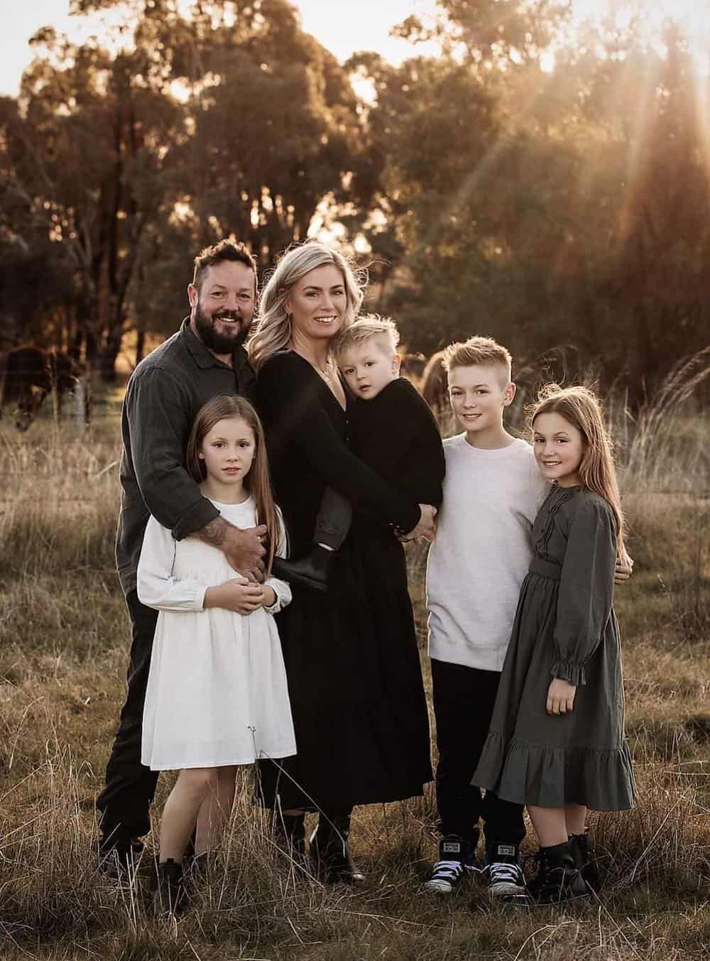 a winter family photoshoot with outfits featuring black, white, and grey outfits