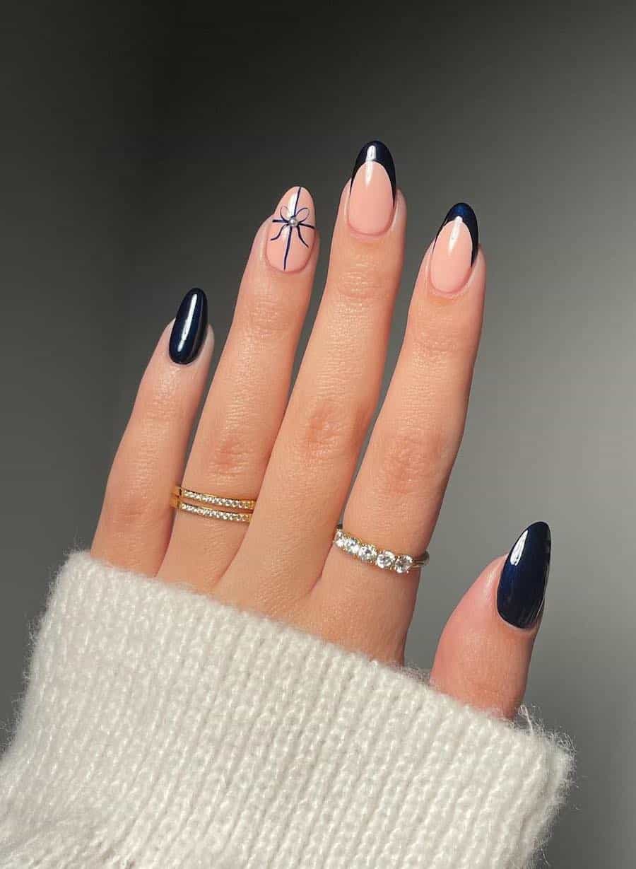 nude and navy blue nails with french tips and a bow tie accent nail