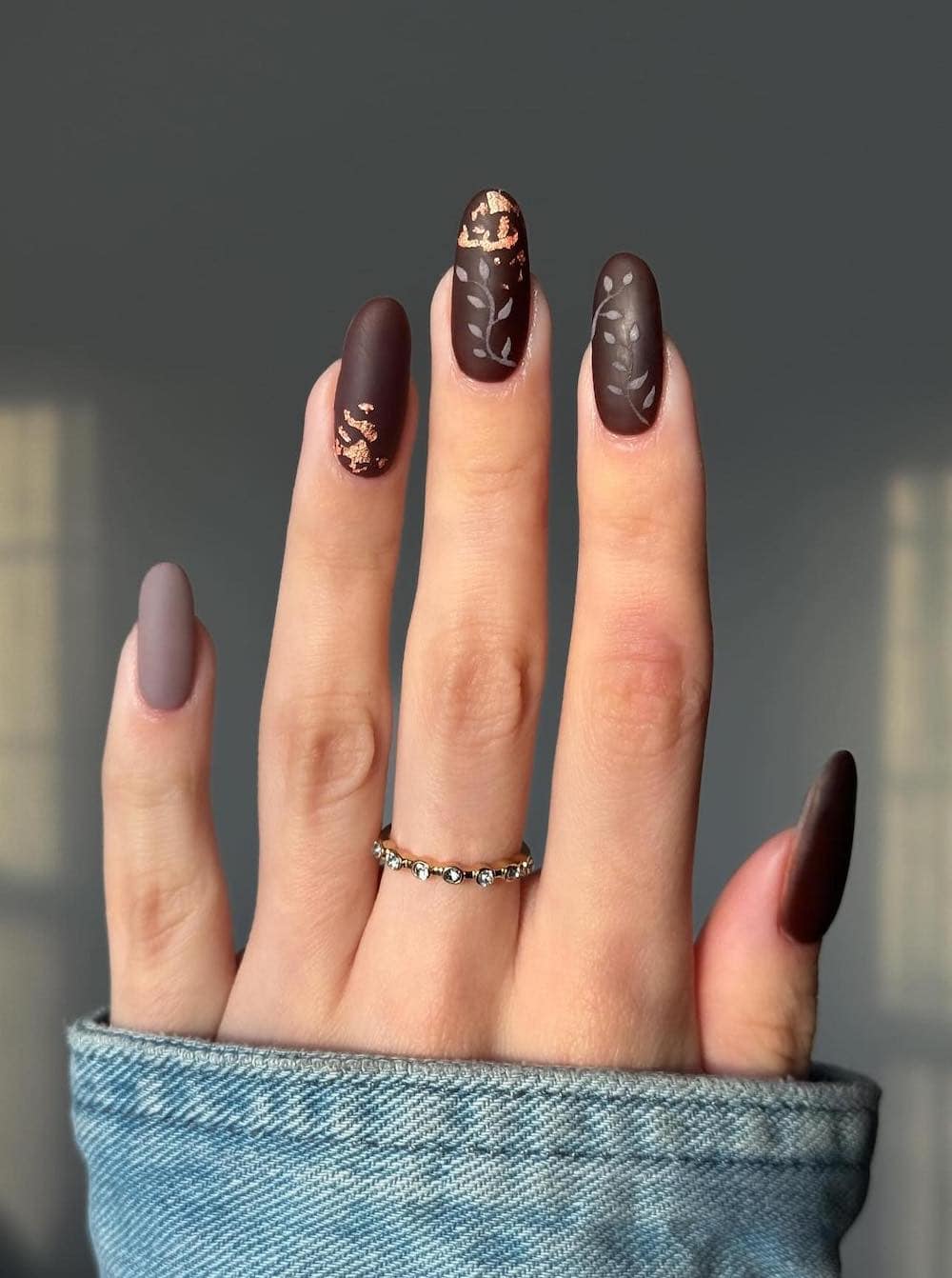 long brown matte nails with leaf art and gold foil