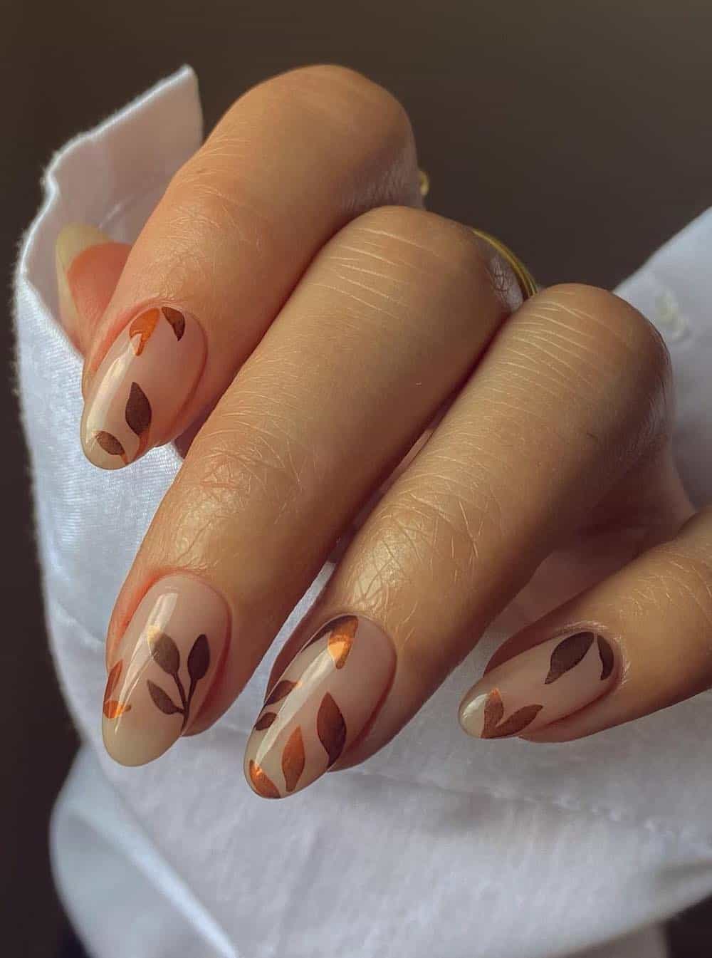 short nude almond nails with brown and copper leaf art