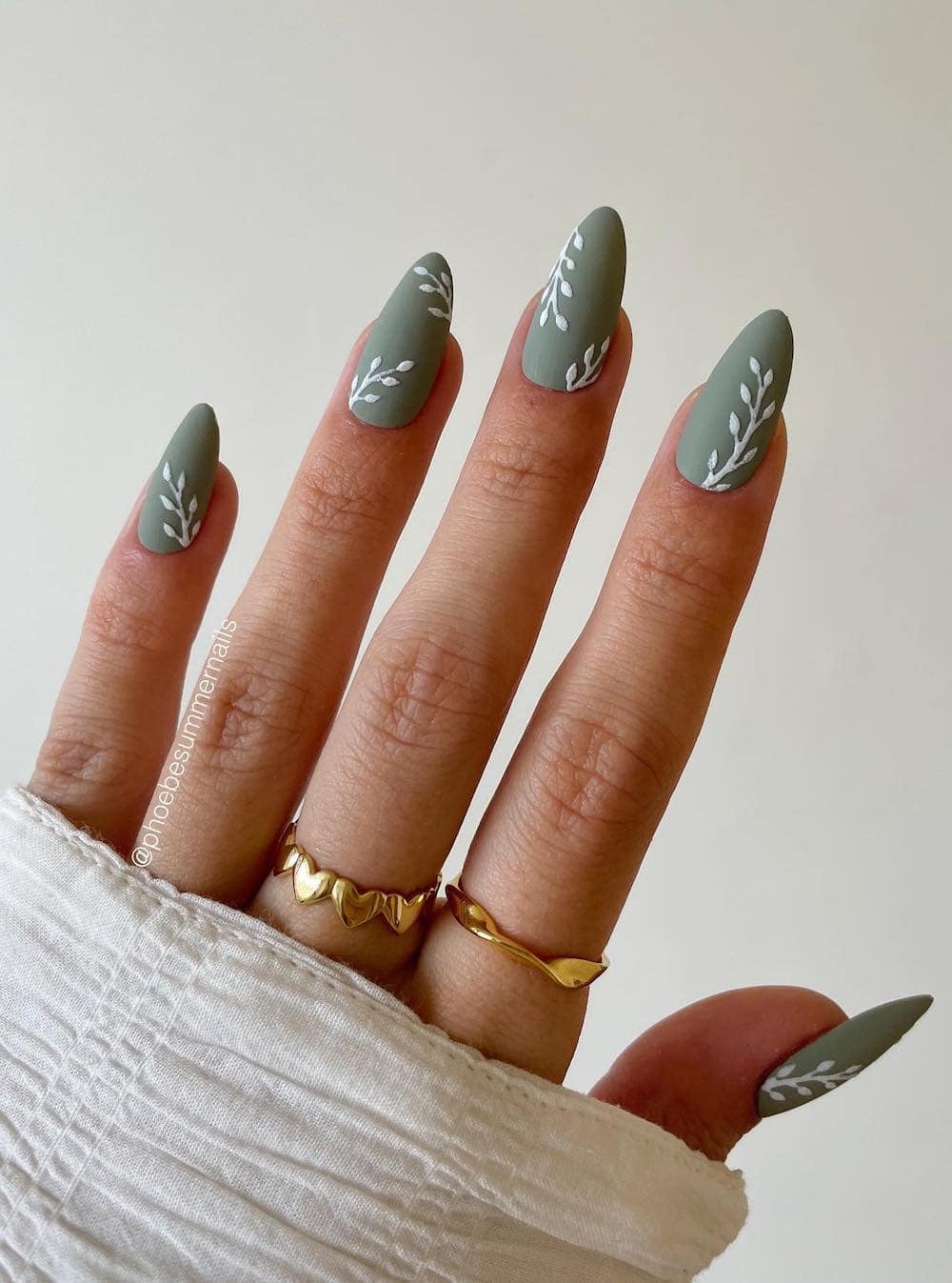 medium matte green almond nails with white leaf art