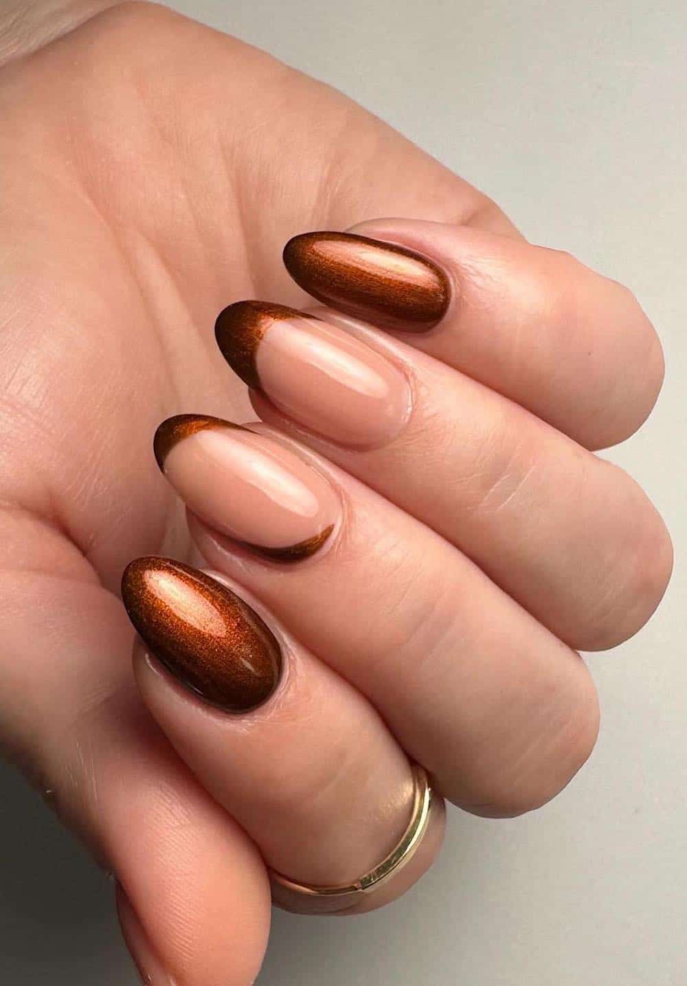 short nude almond nails with bronze polish and french tip accent nails