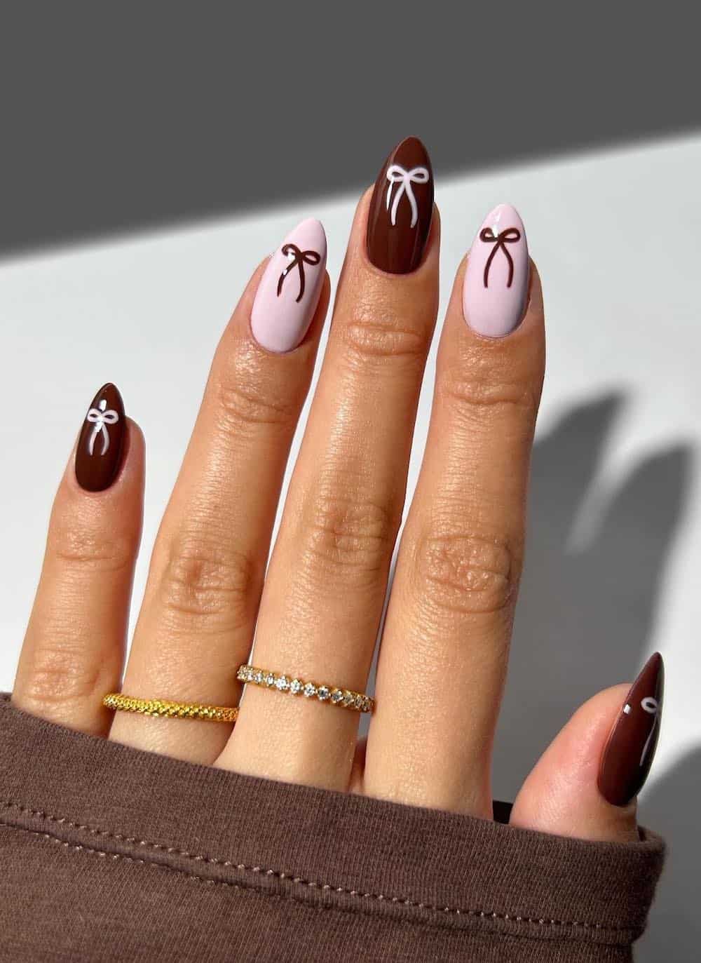 medium burgundy and light pink almond nails with bow details