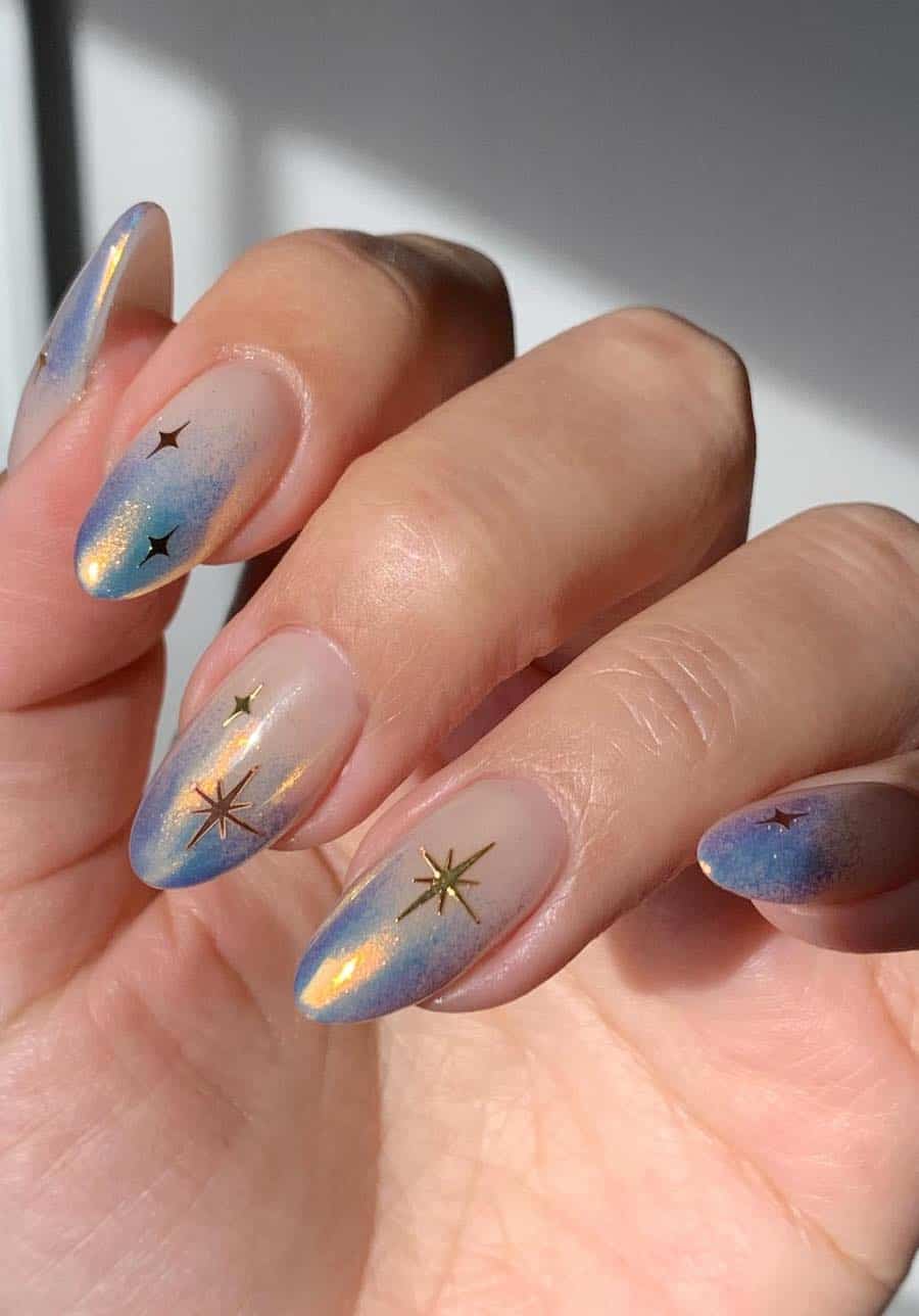 nude to shimmering blue omnre nails with gold stars