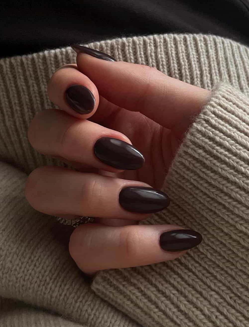 medium almond nails with dark brown polish