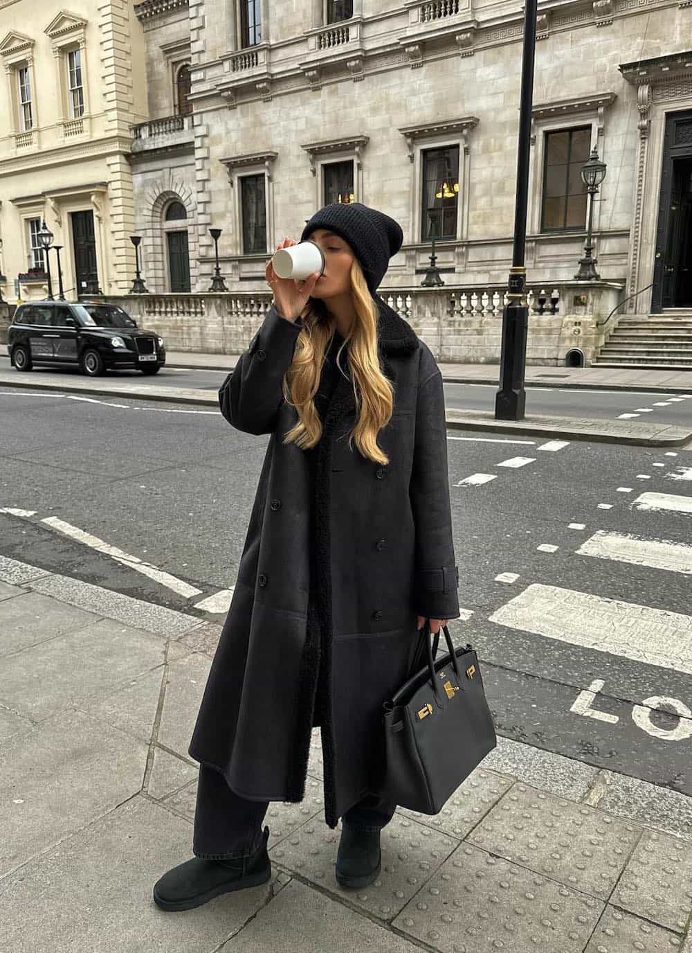 Woman wearing all black with black Ugg boots.