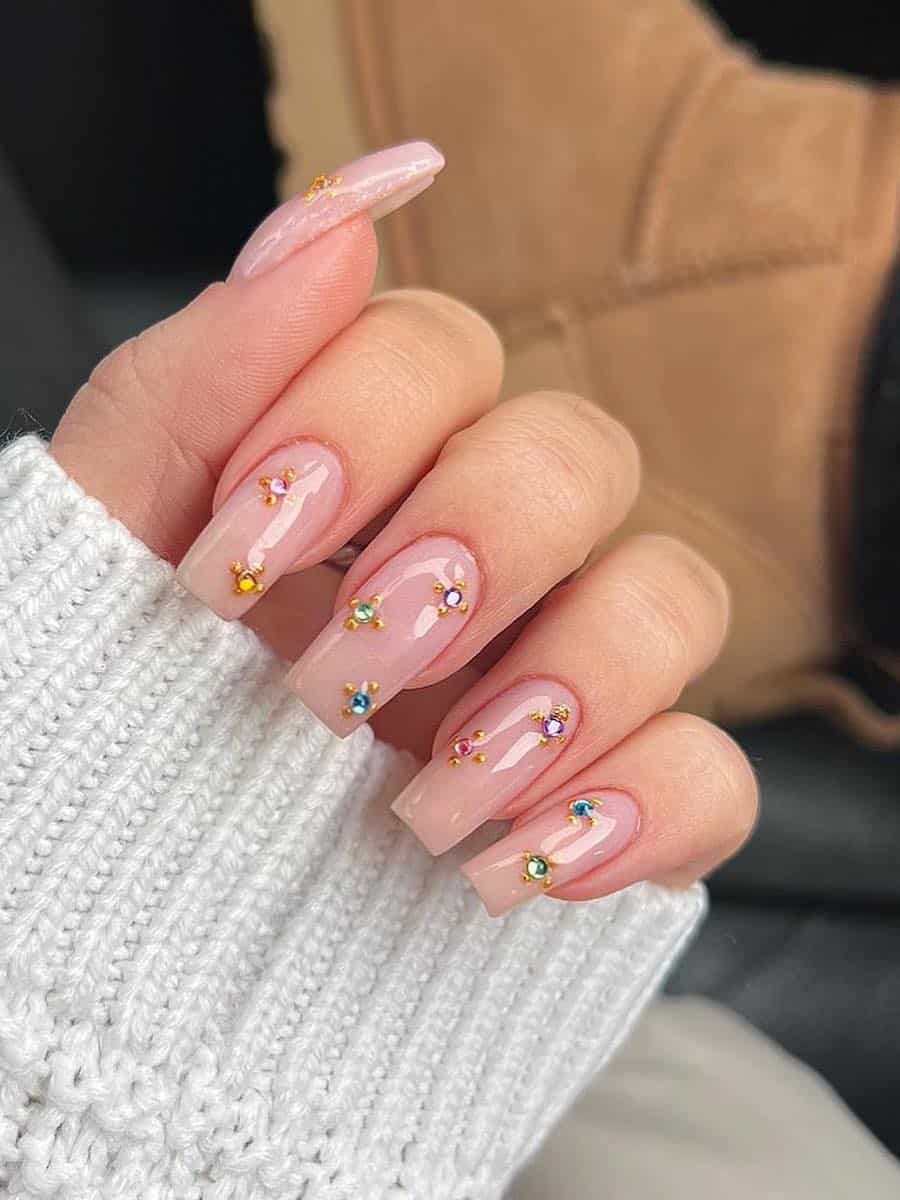 long nude square nails with colorful gem accents