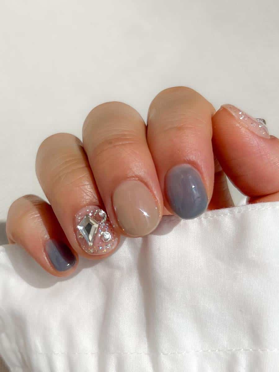 short beige and grey nails with gem accents