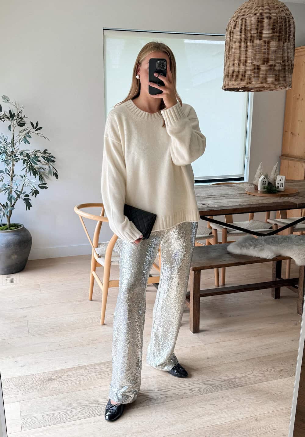 Christal wearing silver sequin pants, black ballet flats and an oversized cream sweater.