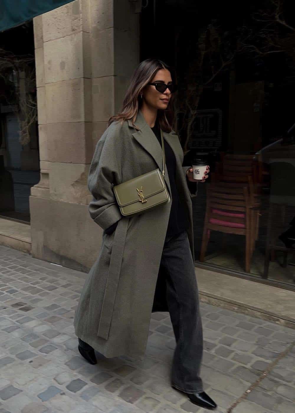 Woman wearing jeans and a long oversized coat with booties.