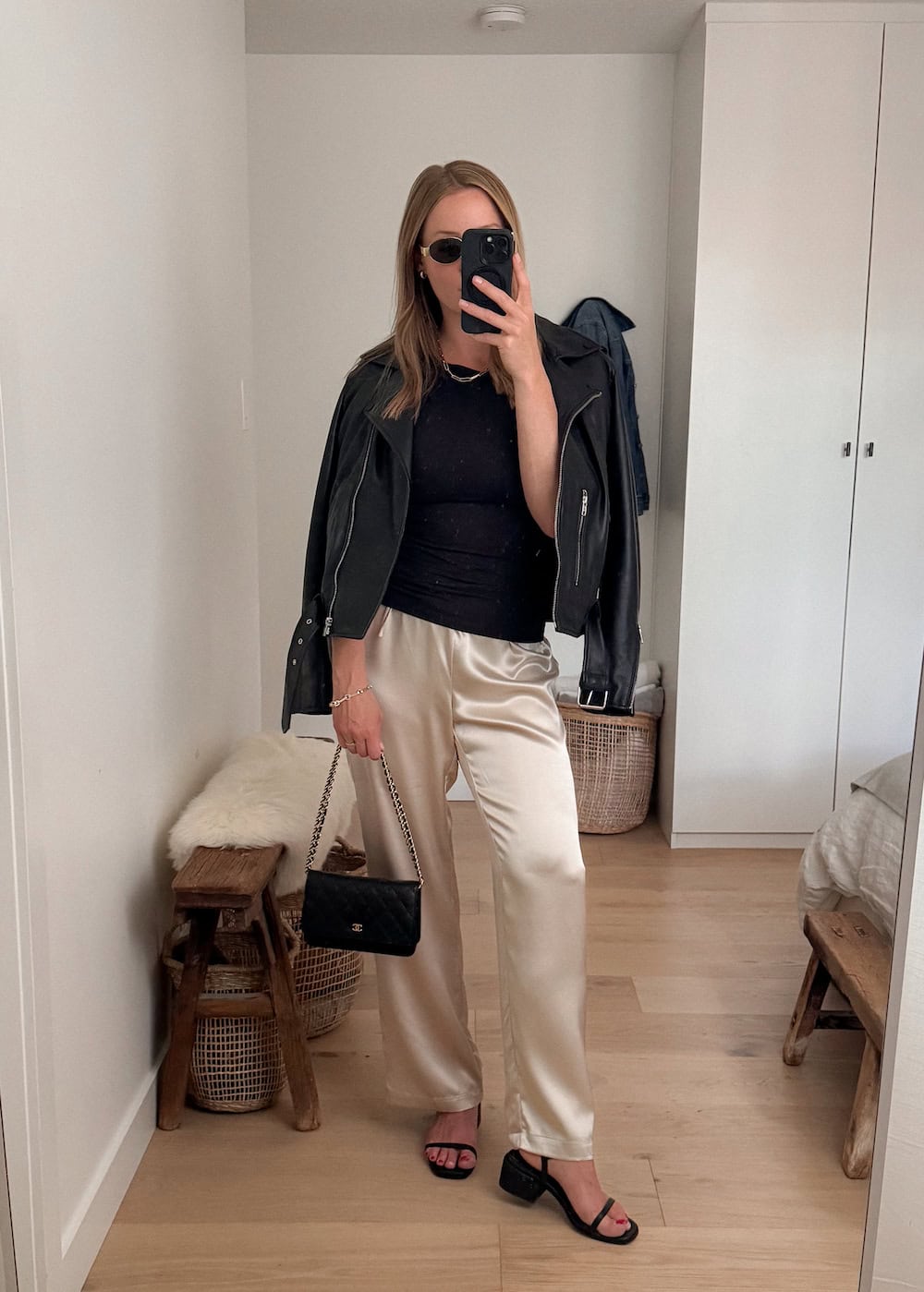 Christal wearing silk trousers with black block heels and a black leather jacket.