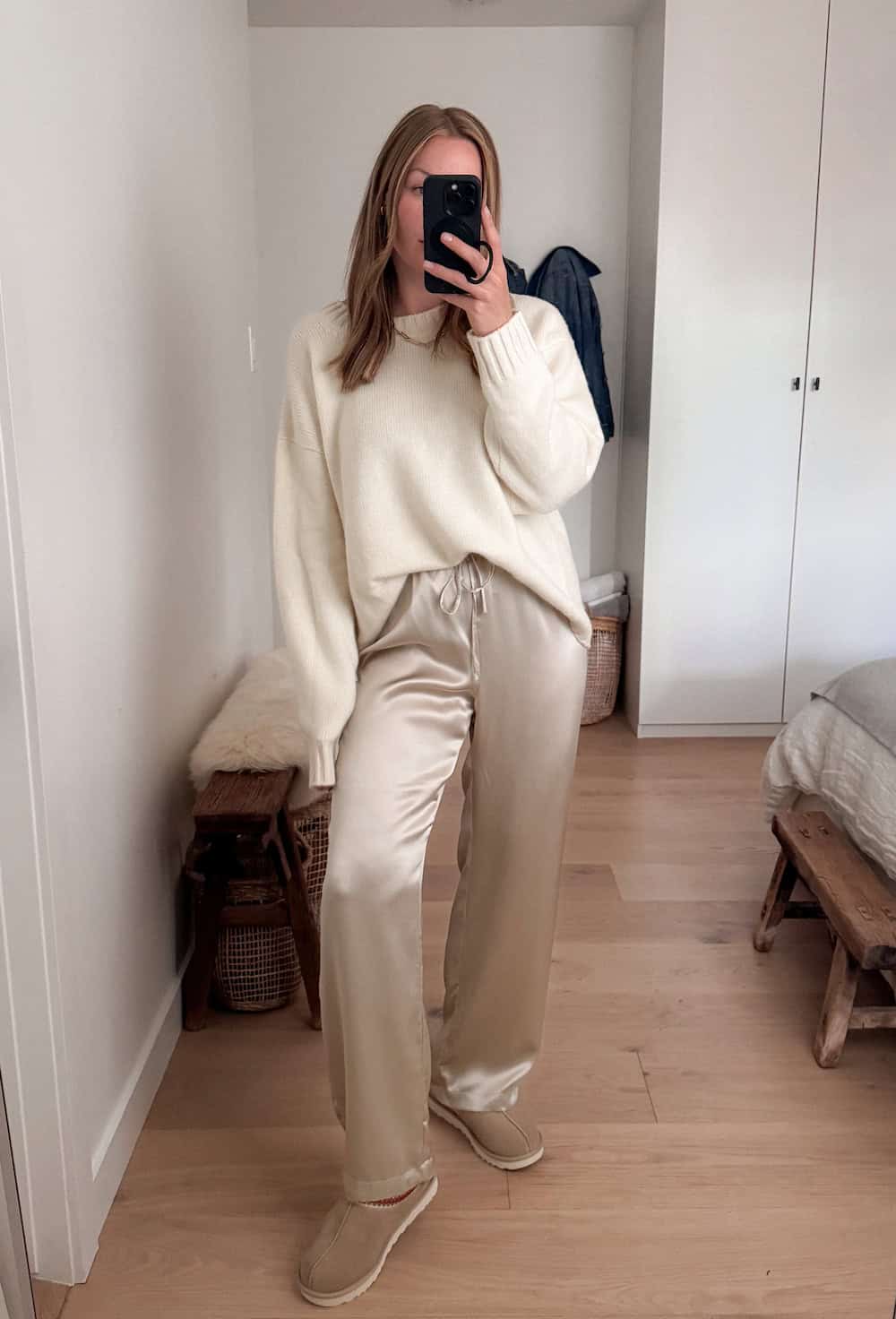 Christal wearing silk trousers and a white sweater with Ugg slippers.