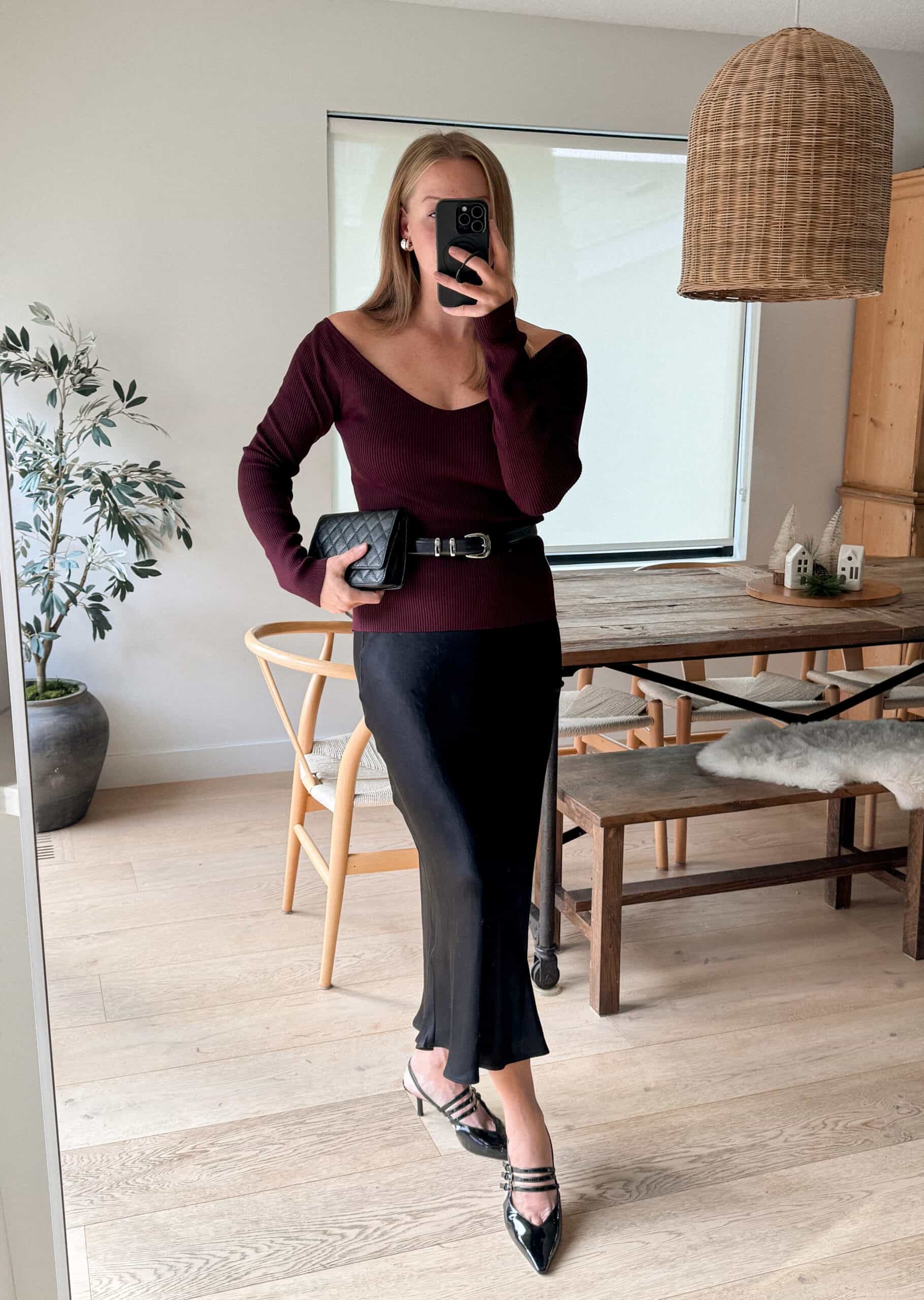 Christal wearing a black slip skirt with a dark red off the shoulder top and black pumps.