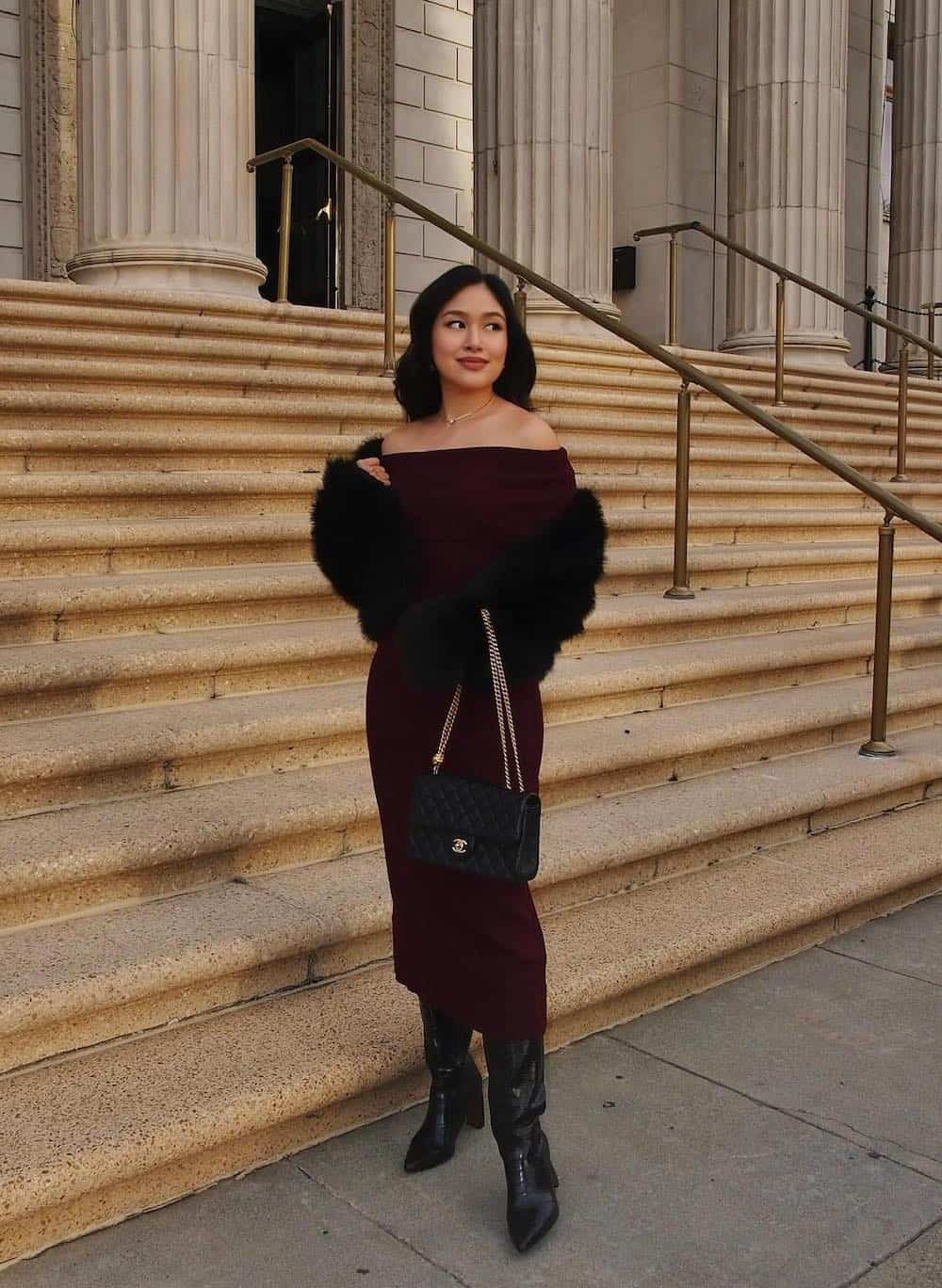 Woman wearing a Burgundy sweater dress with tall black boots.