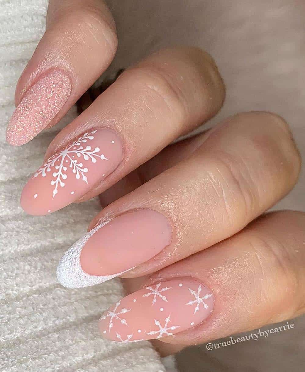 long nude pink nails with white glitter french tips, accent nails, and snowflakes