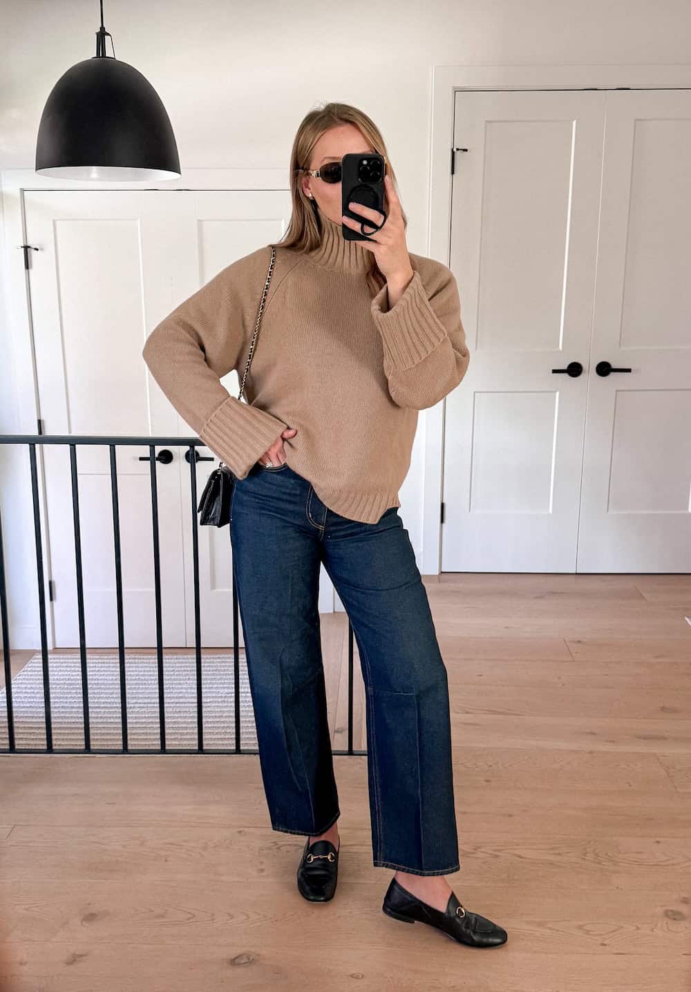 Christal wearing wide-leg jeans a turtleneck sweater and loafers.