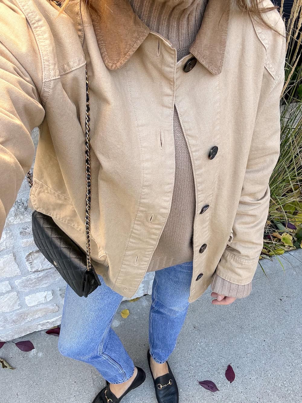 Christal wearing straight jeans with a turtleneck sweater, a brown coat and loafers.